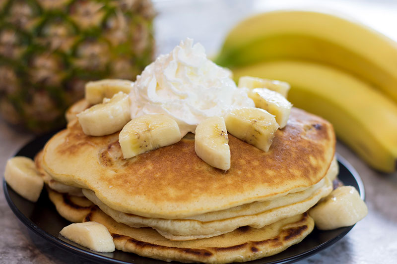 Banana pancakes are delicious with macadamia nuts and honey butter.